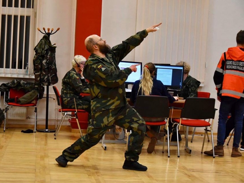 Rankoje dezinfekcinė servetėlė, ant rankovės trikampis antsiuvas, partizanų kokarda 